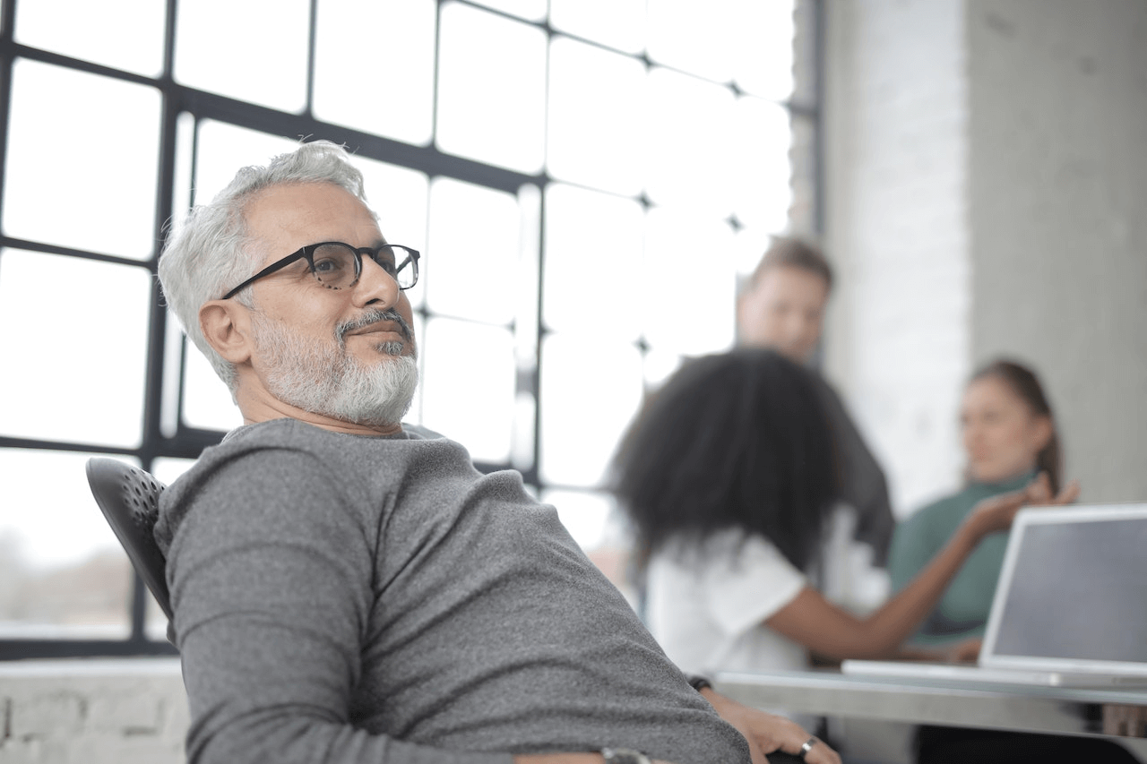 https://www.pexels.com/photo/satisfied-gray-haired-bearded-businessman-with-laptop-against-diverse-colleagues-3865598/