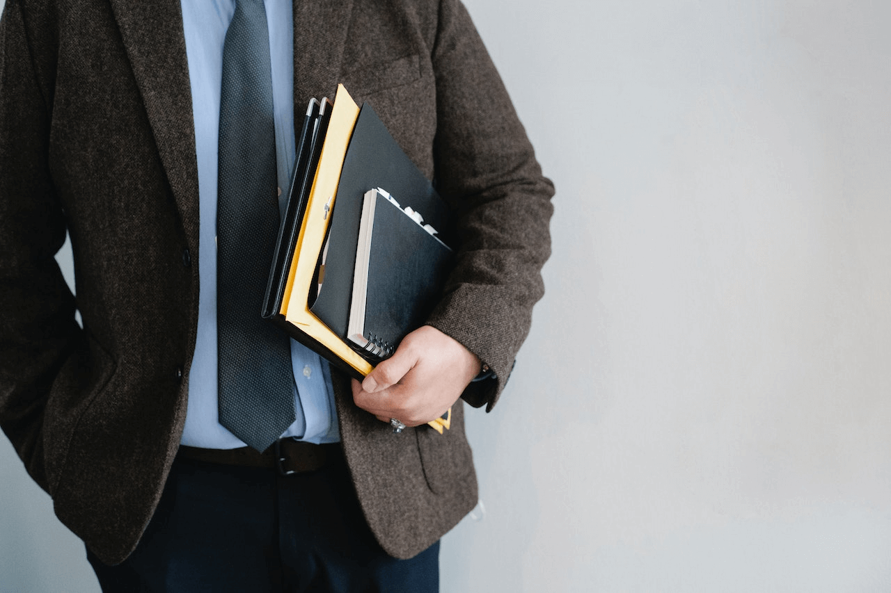 https://www.pexels.com/photo/crop-unrecognizable-office-worker-standing-with-papers-in-hand-5668765/