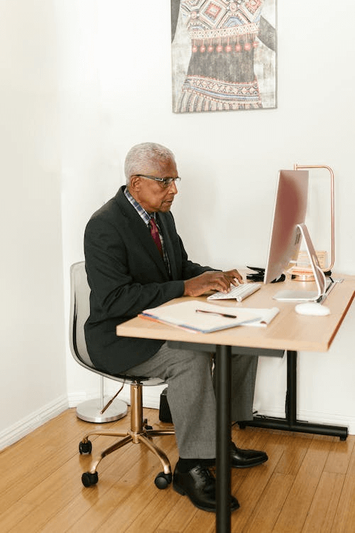 https://www.pexels.com/photo/elderly-man-working-at-the-office-8123851/