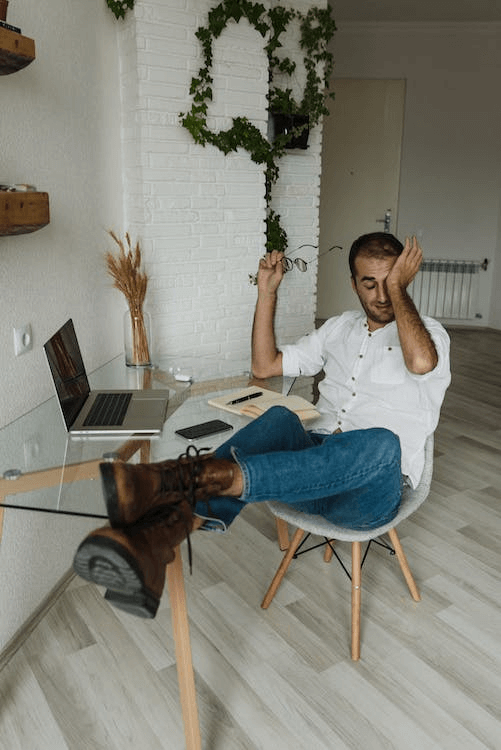 https://www.pexels.com/photo/a-man-sitting-on-a-chair-rubbing-his-eyes-5712134/