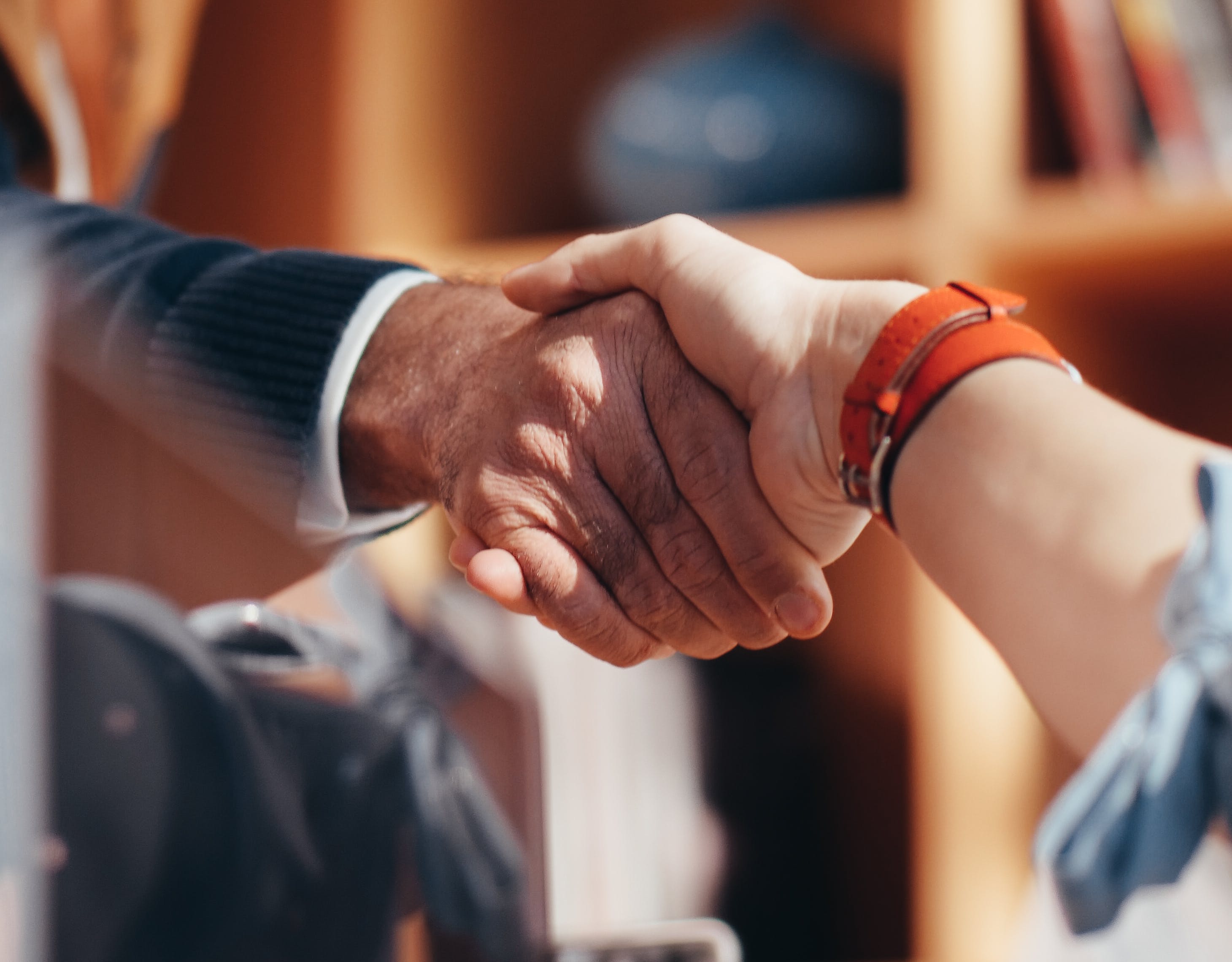 Free Man in Black Suit Holding Hands of Woman in Orange Long Sleeve Shirt Stock Photo